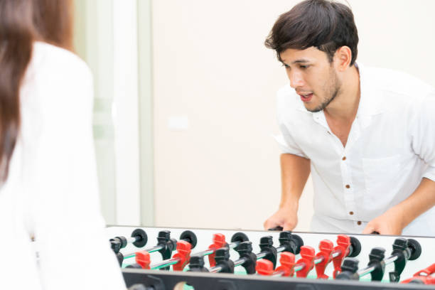 istock Happy couple playing foosball table. 1004681394