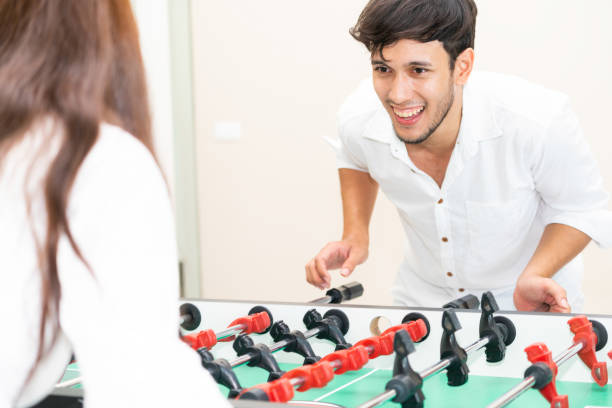 istock Happy couple playing foosball table. 1004681400