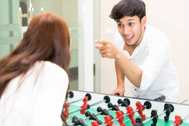 istock Happy couple playing foosball table. 1004681402