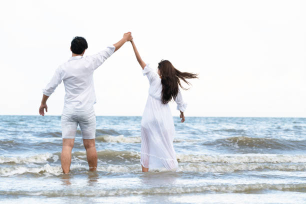 Couple going honeymoon on tropical beach in summer
