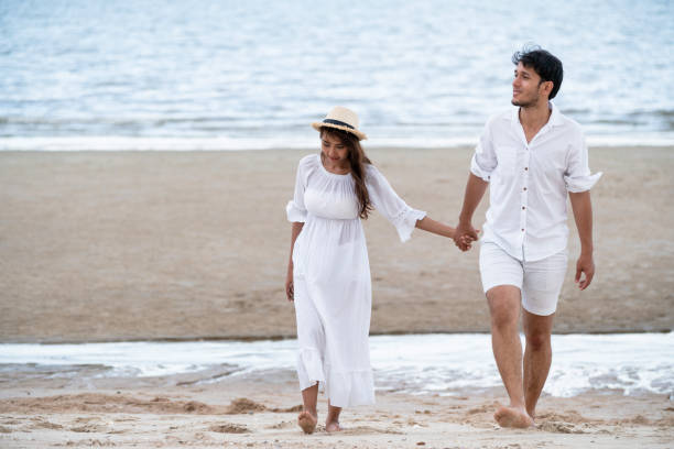 istock Happy young couple walk on the beach on honeymoon. 1004681670