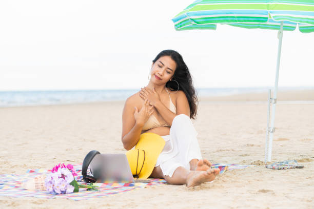 istock Plus size young woman sitting on the beach. 1004681772