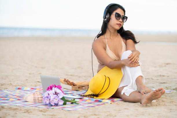 istock Plus size young woman sitting on the beach. 1004681774