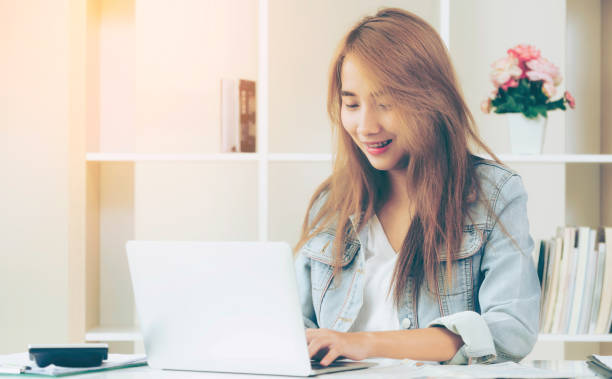 Happy woman works on computer in home office.