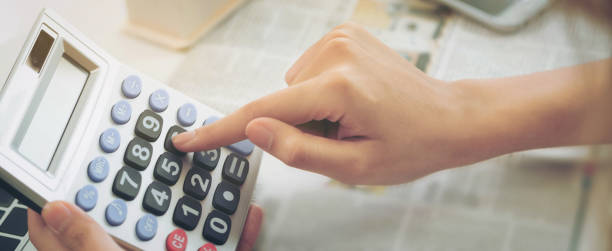 Woman accountant or bank worker uses calculator.