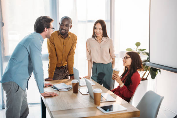 istock interracial group of business colleagues discussing work during coffee break at workplace in office 1004695200