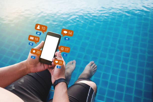 istock a man using mobile phone at poolside in summer with social media and online message notification icons, blank white screen 1004709424