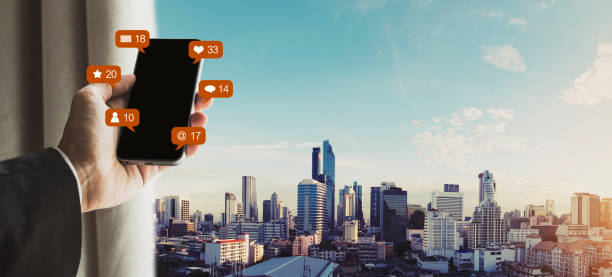 istock Hand using mobile smart phone with social media, social network and online message notification icons, Bangkok city view 1004711726