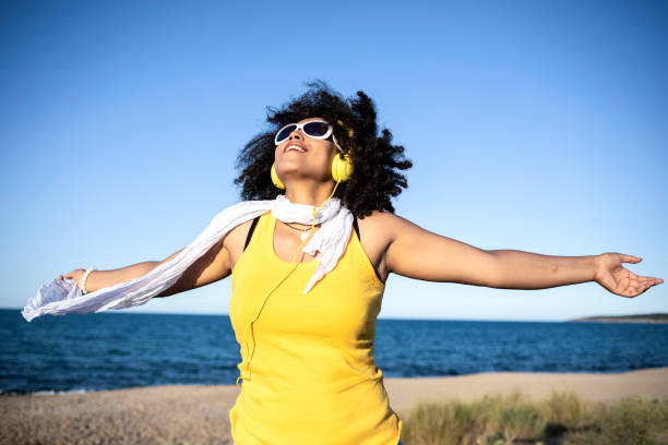istock Cheerful african woman having fun on the beach 1004712154