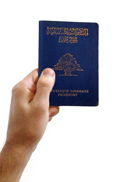 Hand holding an Lebanese passport against a white background Close-up on a man's hand holding an Lebanese passport against a white background. lebanese culture stock pictures, royalty-free photos & images