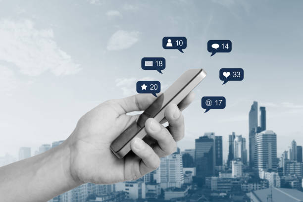 istock Hand holding mobile smart phone, with social media and social network notification icon 1004723042