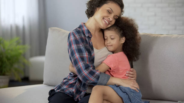 istock Beloved mother tightly hugging her little daughter, full trust and affection 1004734592
