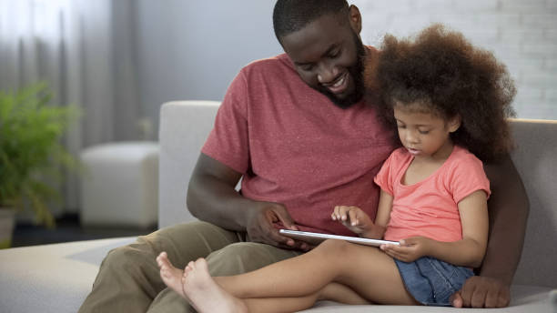 istock Dad and daughter playing educational games on tablet, having fun together 1004734696