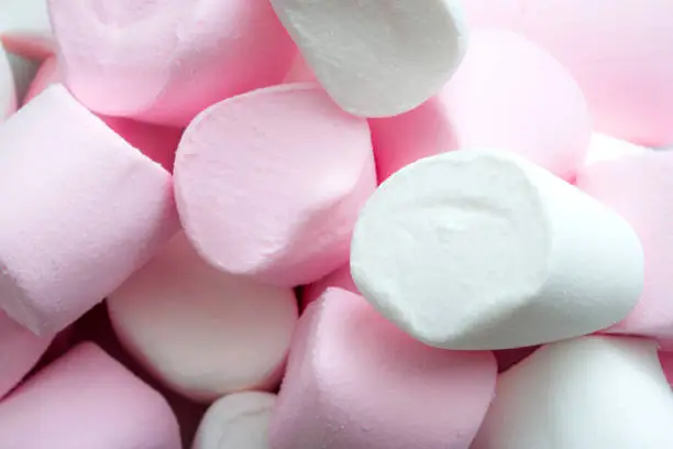 Sugar-based confectionery and sweet candy concept with macro closeup on pink and white fluffy marshmallows with copy space