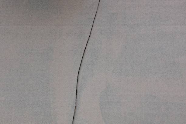 istock gray texture of a concrete wall and a black crack 1004771816