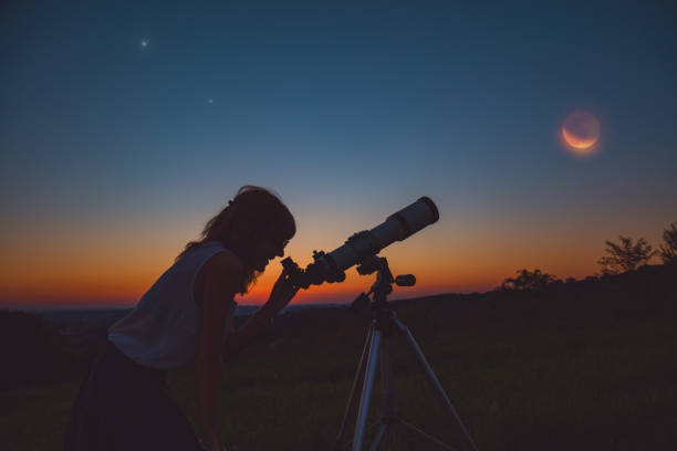 istock Girl looking at lunar eclipse through a telescope. My astronomy work. 1004771996