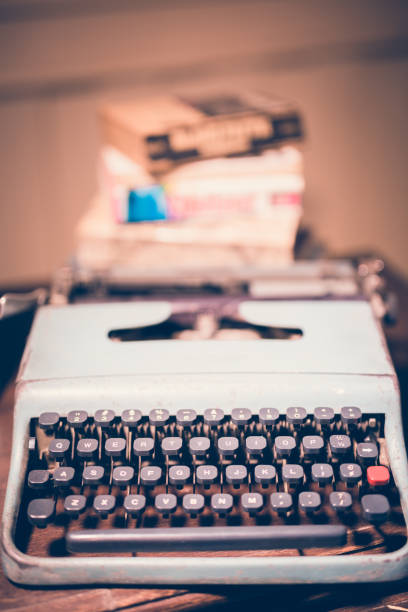 istock Typewriter antique vintage style with old documents or old letter and books for writer on wooden desk zoom in front view of typewriter writer or editor in vintage office concept. 1004779106