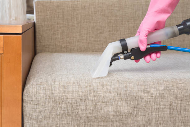 istock Dry cleaner's employee hand cleaning sofa with professionally extraction method. Textile upholstered furniture. Early spring regular cleanup. Commercial cleaning company. Service concept. 1004793124