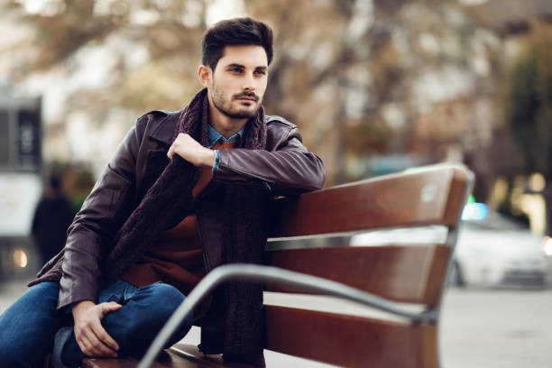 istock Thoughtful young man sitting on an urban bench. 1004798124
