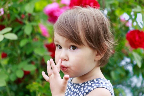 urocza mała dziewczynka zbierająca nos - picking nose zdjęcia i obrazy z banku zdjęć