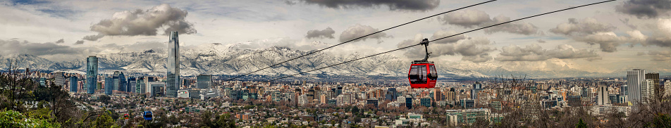 Panoramic view of Santiago from the Metropolitan Park, towards the mountain range after a historical snowfall in Chile. With emphasis on the Costanera Center building and the cable car.