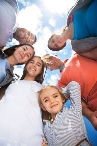 istock Group of happy smiling friends against blue sky 1004806636