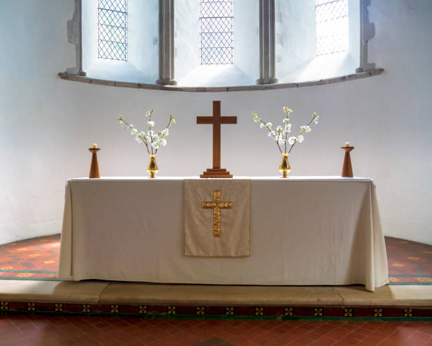Simply dressed altar in an English church A simply furnished altar on a clean white altar cloth inside the parish church of St Martin of Tours parish church in the pretty village of Eynsford in Kent, Southeast England. altar photos stock pictures, royalty-free photos & images