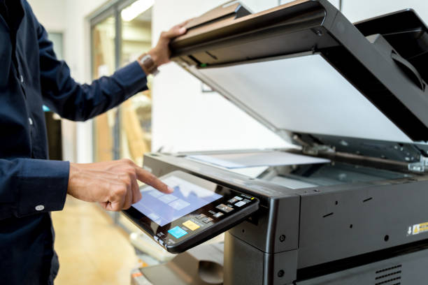 istock Business man Hand press button on panel of printer, printer scanner laser office copy machine supplies start concept. 1004834886