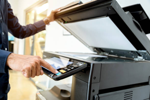 istock Business man Hand press button on panel of printer, printer scanner laser office copy machine supplies start concept. 1004835576