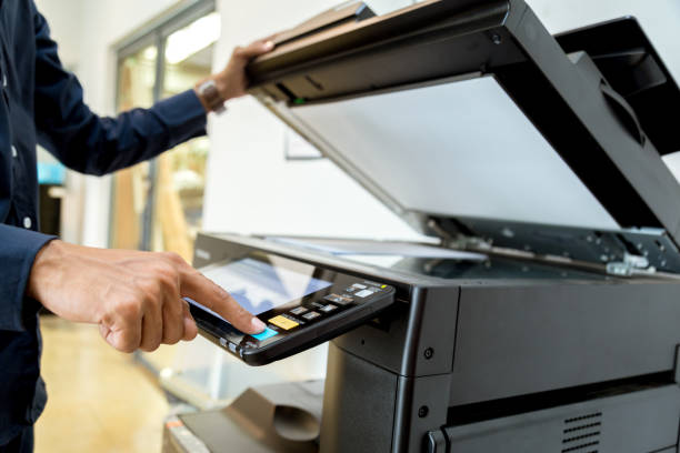 istock Business man Hand press button on panel of printer, printer scanner laser office copy machine supplies start concept. 1004835604