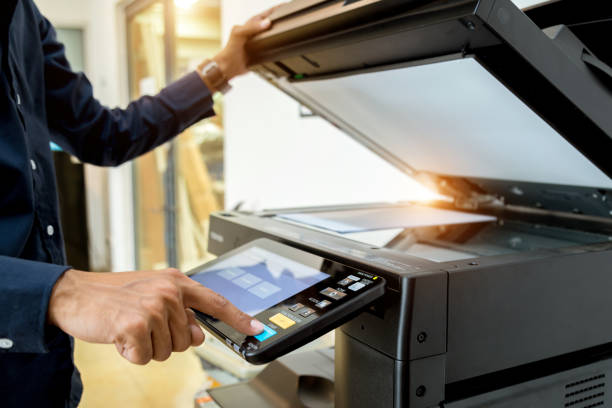istock Business man Hand press button on panel of printer, printer scanner laser office copy machine supplies start concept. 1004835612
