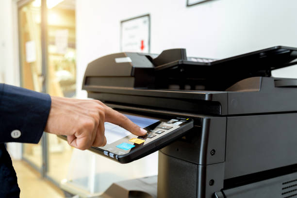istock Business man Hand press button on panel of printer, printer scanner laser office copy machine supplies start concept. 1004835616