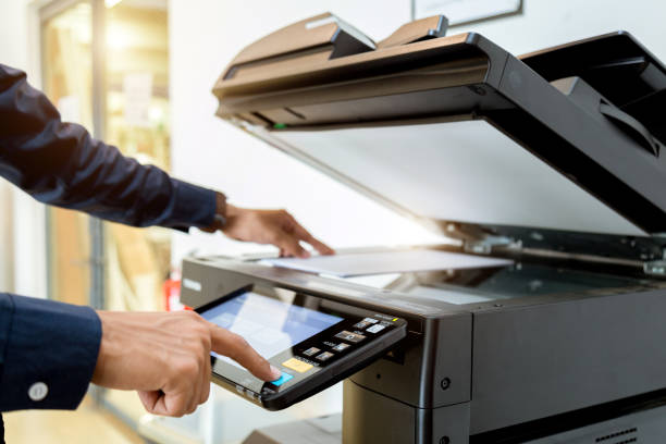 istock Business man Hand press button on panel of printer, printer scanner laser office copy machine supplies start concept. 1004835726
