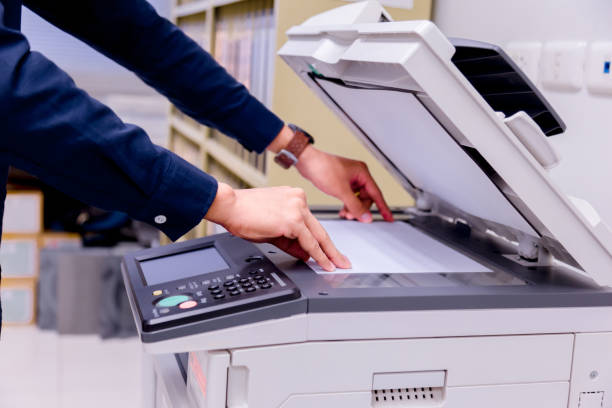 istock Close-up business man Hand press button on panel of printer, printer scanner laser office copy machine supplies start concept. 1004836382