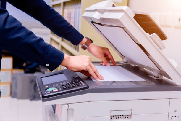 istock Close-up business man Hand press button on panel of printer, printer scanner laser office copy machine supplies start concept. 1004836388