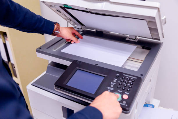 istock Close-up business man Hand press button on panel of printer, printer scanner laser office copy machine supplies start concept. 1004836434