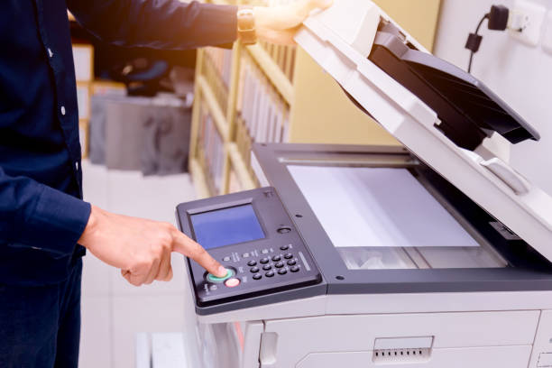 istock Close-up business man Hand press button on panel of printer, printer scanner laser office copy machine supplies start concept. 1004836450