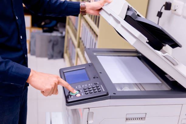 istock Close-up business man Hand press button on panel of printer, printer scanner laser office copy machine supplies start concept. 1004836468