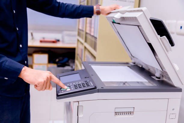 istock Close-up business man Hand press button on panel of printer, printer scanner laser office copy machine supplies start concept. 1004836504