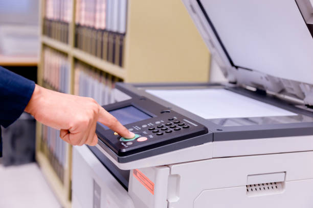 istock Close-up business man Hand press button on panel of printer, printer scanner laser office copy machine supplies start concept. 1004838568
