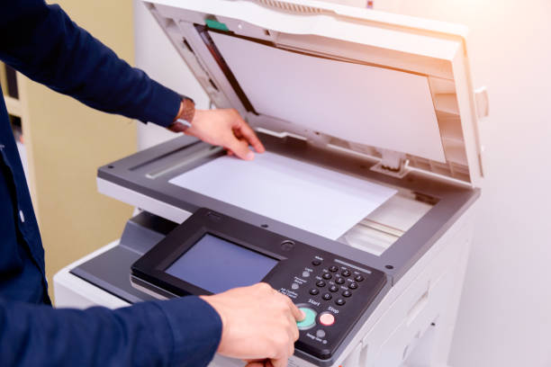 istock Close-up business man Hand press button on panel of printer, printer scanner laser office copy machine supplies start concept. 1004838830