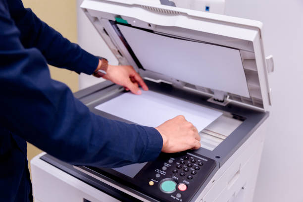 istock Close-up business man Hand press button on panel of printer, printer scanner laser office copy machine supplies start concept. 1004838860