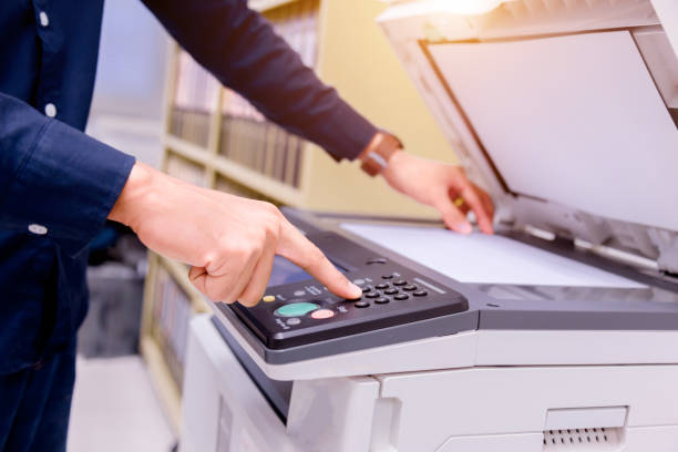 istock Close-up business man Hand press button on panel of printer, printer scanner laser office copy machine supplies start concept. 1004838904