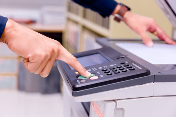 istock Close-up business man Hand press button on panel of printer, printer scanner laser office copy machine supplies start concept. 1004839164