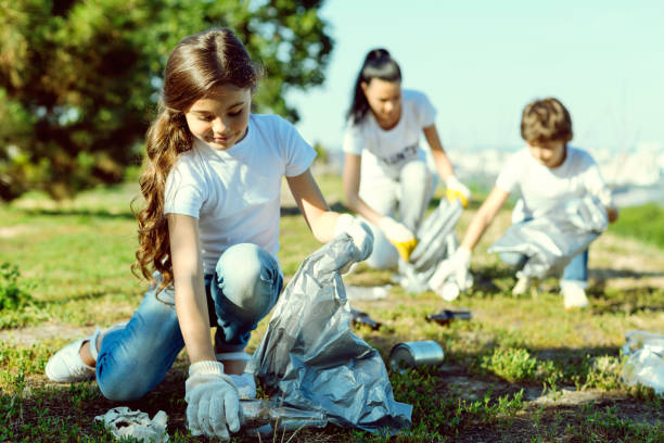 istock Attentive kid gathering rubbish into bag 1004848040