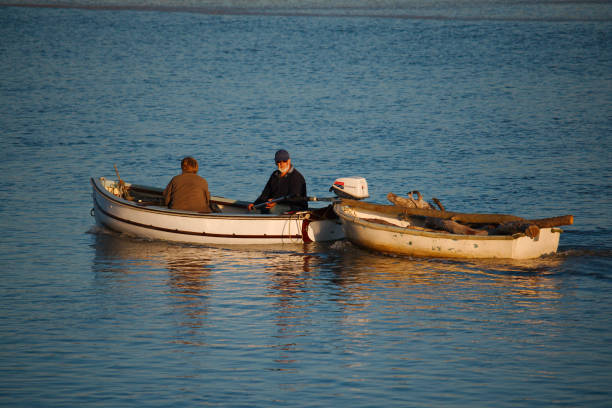 a man and woman transporting wood along a river - escaping the rat race imagens e fotografias de stock