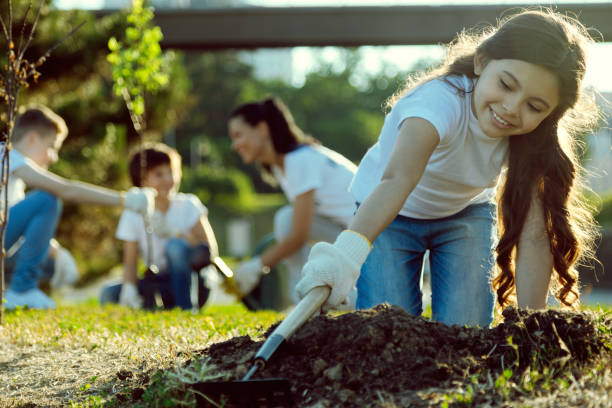 istock Careful longhaired girl standing on knees while gardening 1004853068