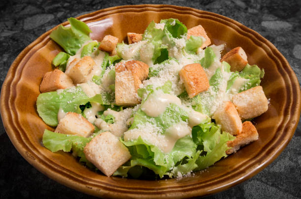 istock Caesar salad with cream sauce on top with croutons in plate. 1004856570