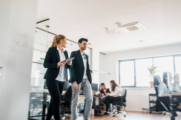 istock Businesspeople walking in the office and using a digital tablet 1004862278