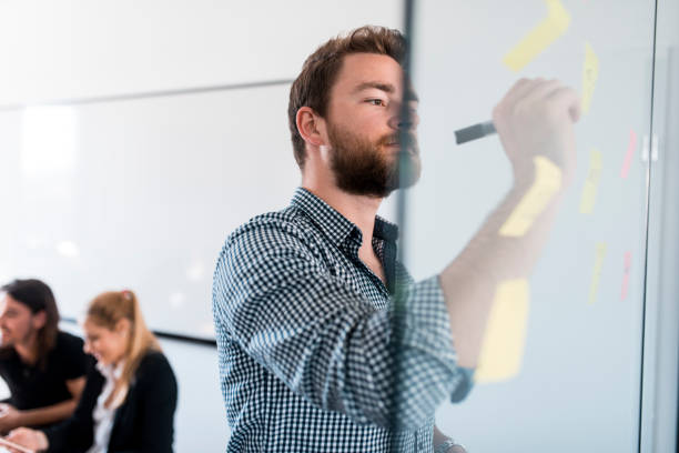 istock Businessman writing new ideas on adhesive notes in the office 1004862370